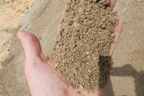 hand with paver base material